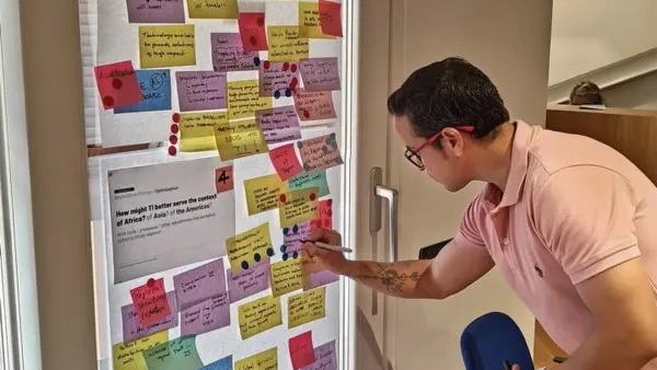 International IT strategy workshop in Rome: a wall of sticky notes answering how to serve Africa, Asia and the Americas better